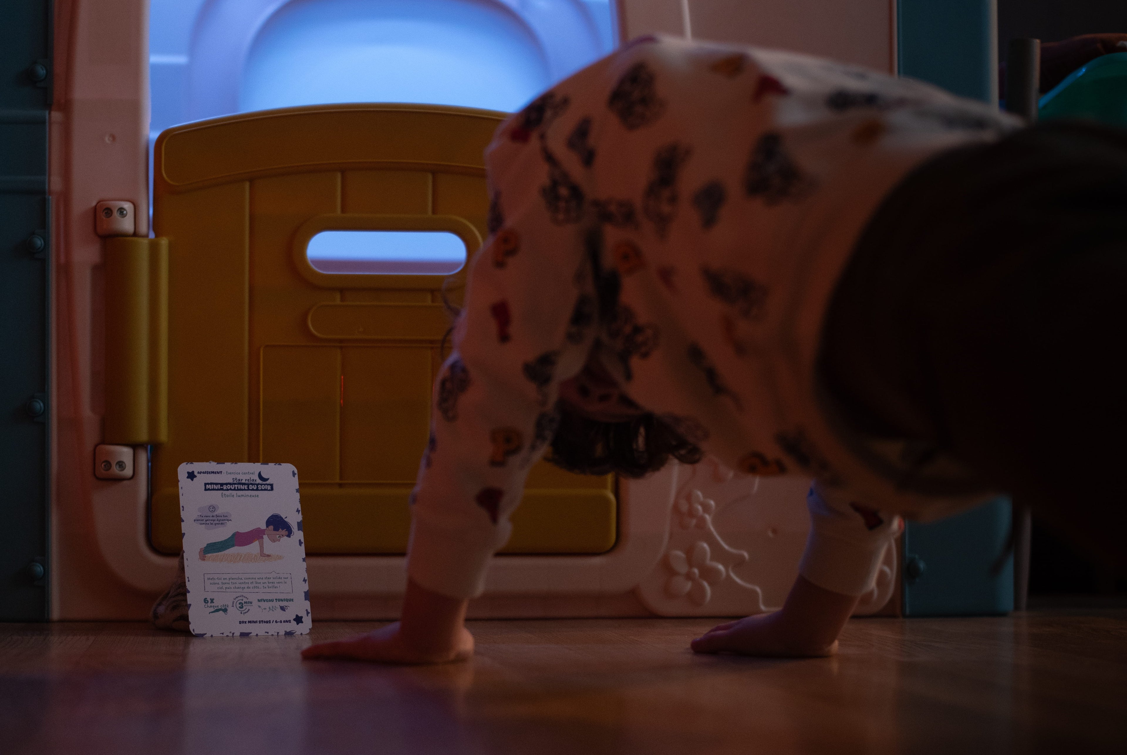 enfant faisant du sport avec carte ludique à la maison